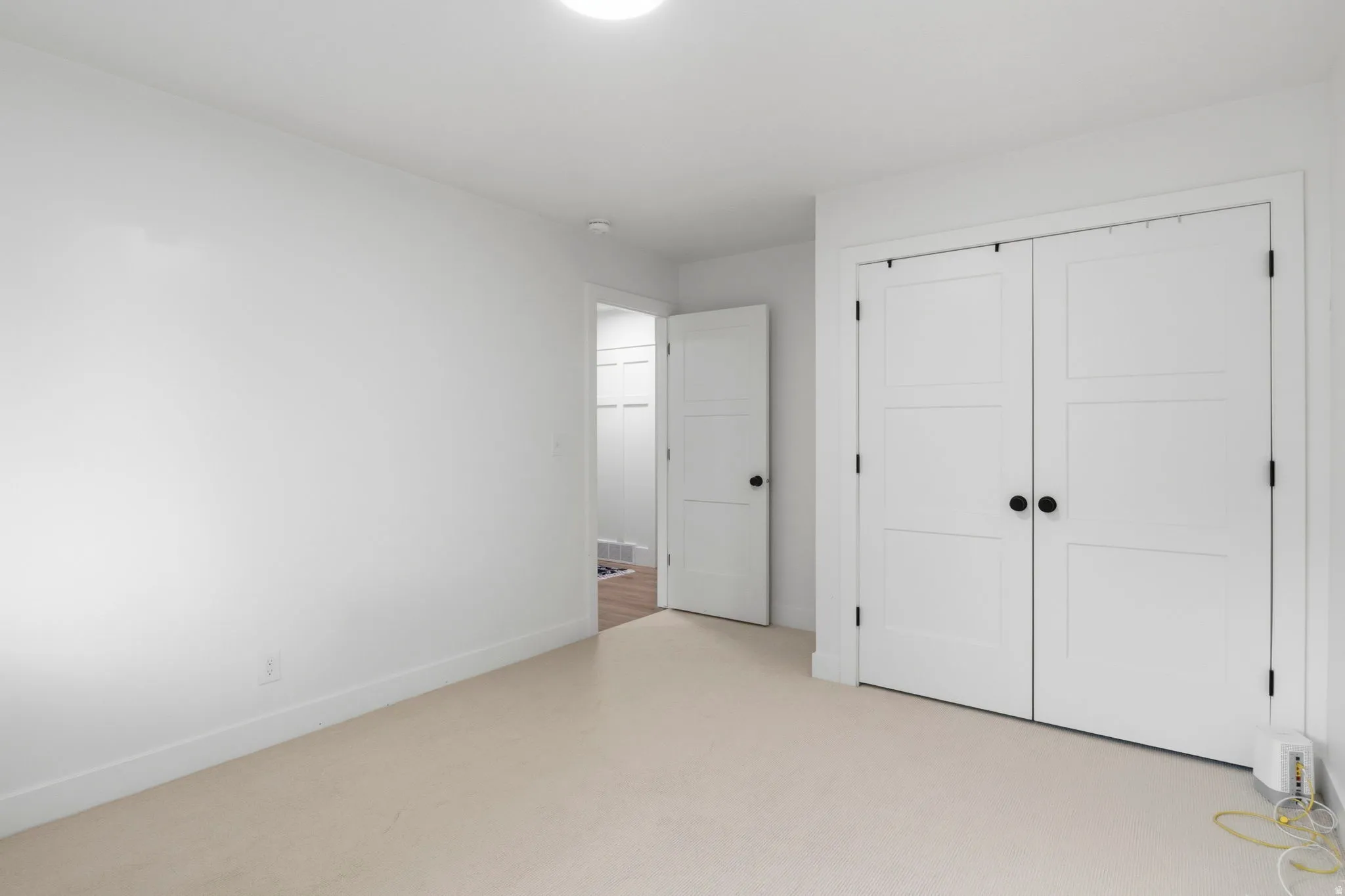 Neutral tone carpeting with white baseboards