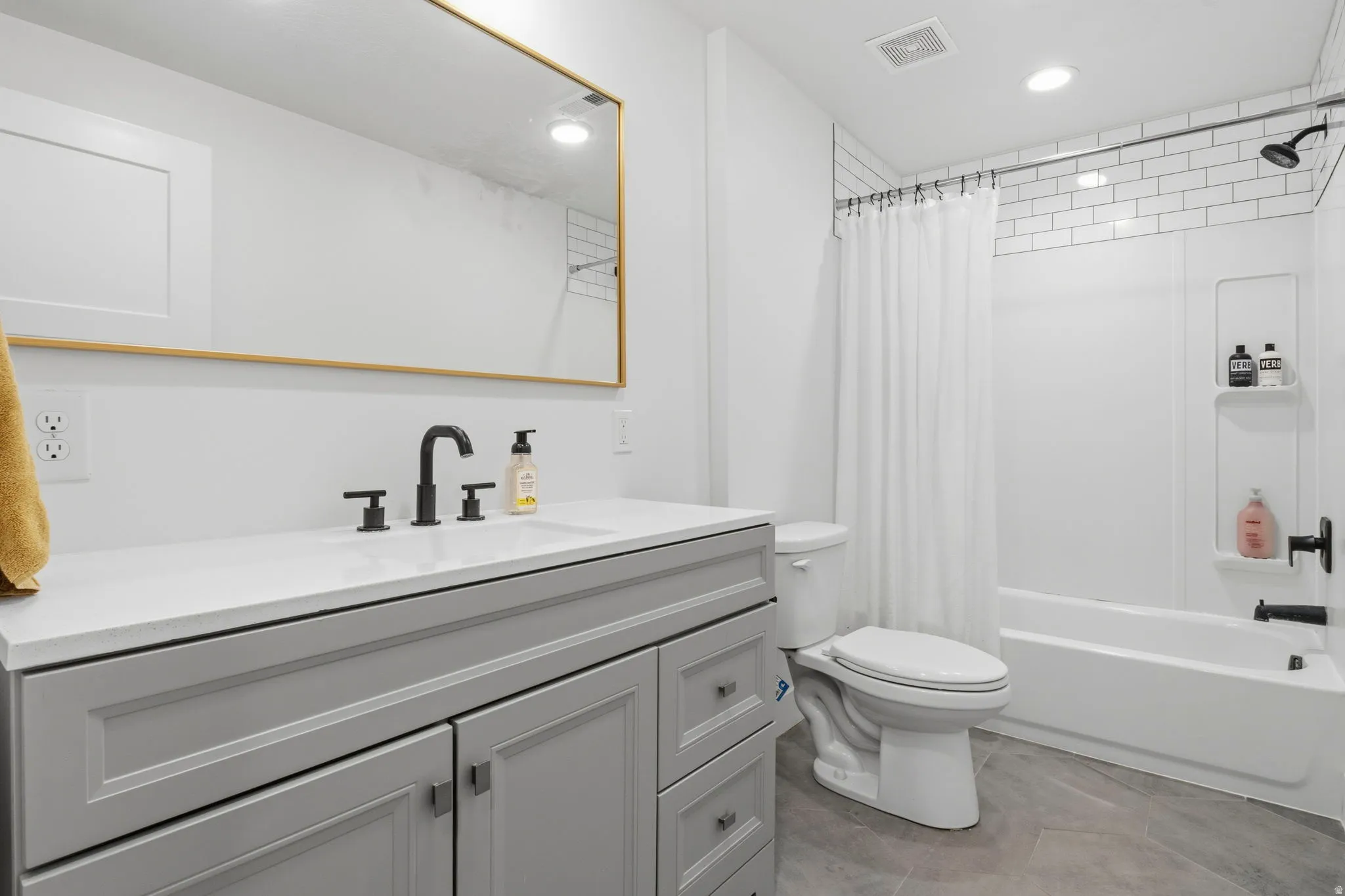 Contemporary bathroom featuring a light gray vanity with a white countertop and matte black fixtures
