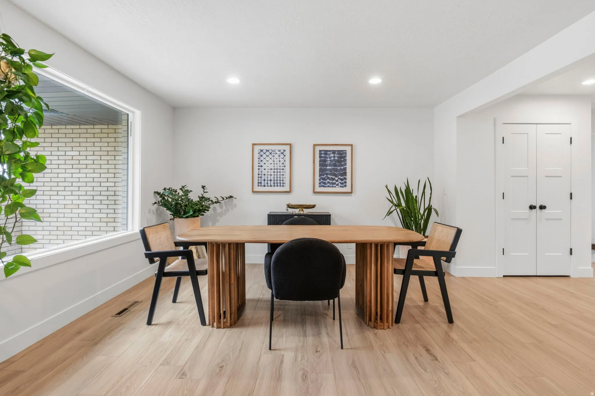 Light wood-finish flooring complements white walls and recessed lighting