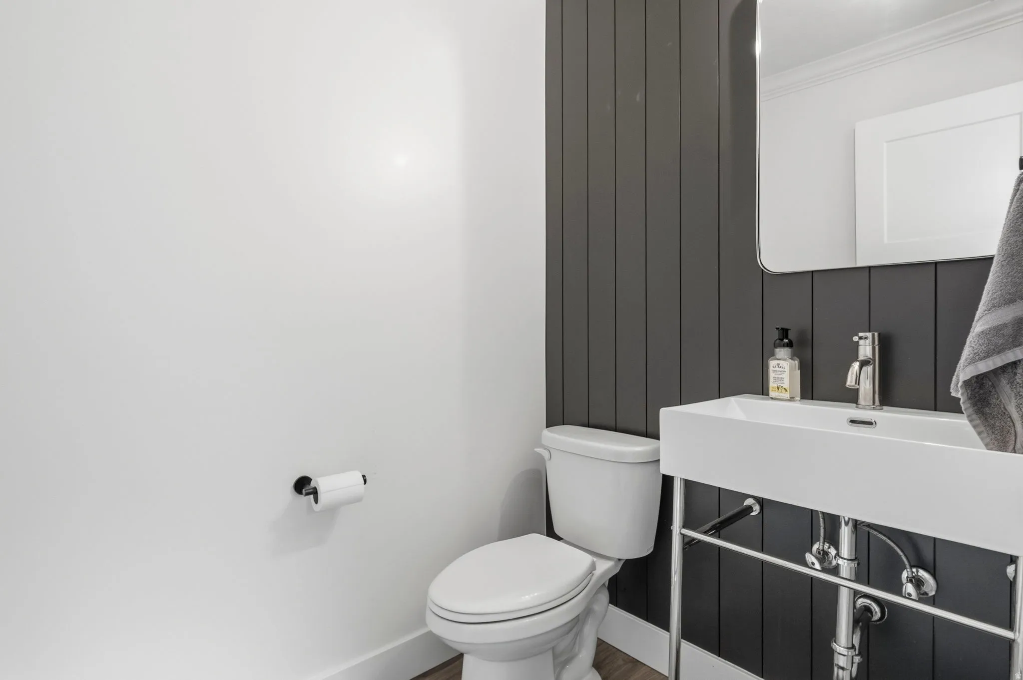 Contemporary powder room featuring a wall-mounted rectangular sink with chrome fixtures, a modern toilet, and a sleek rectangular mirror