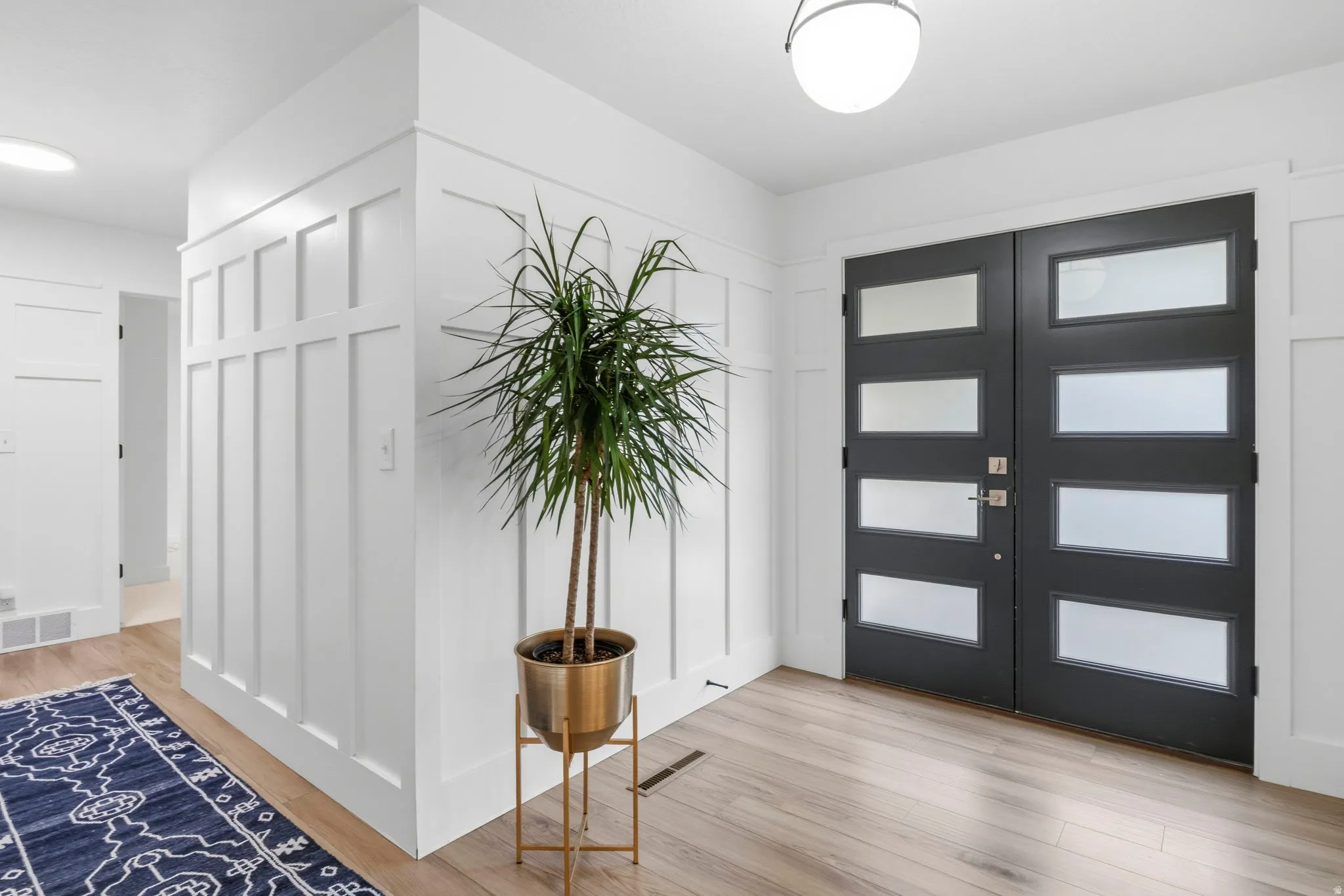 Double entry doors featuring frosted glass panels and a dark finish