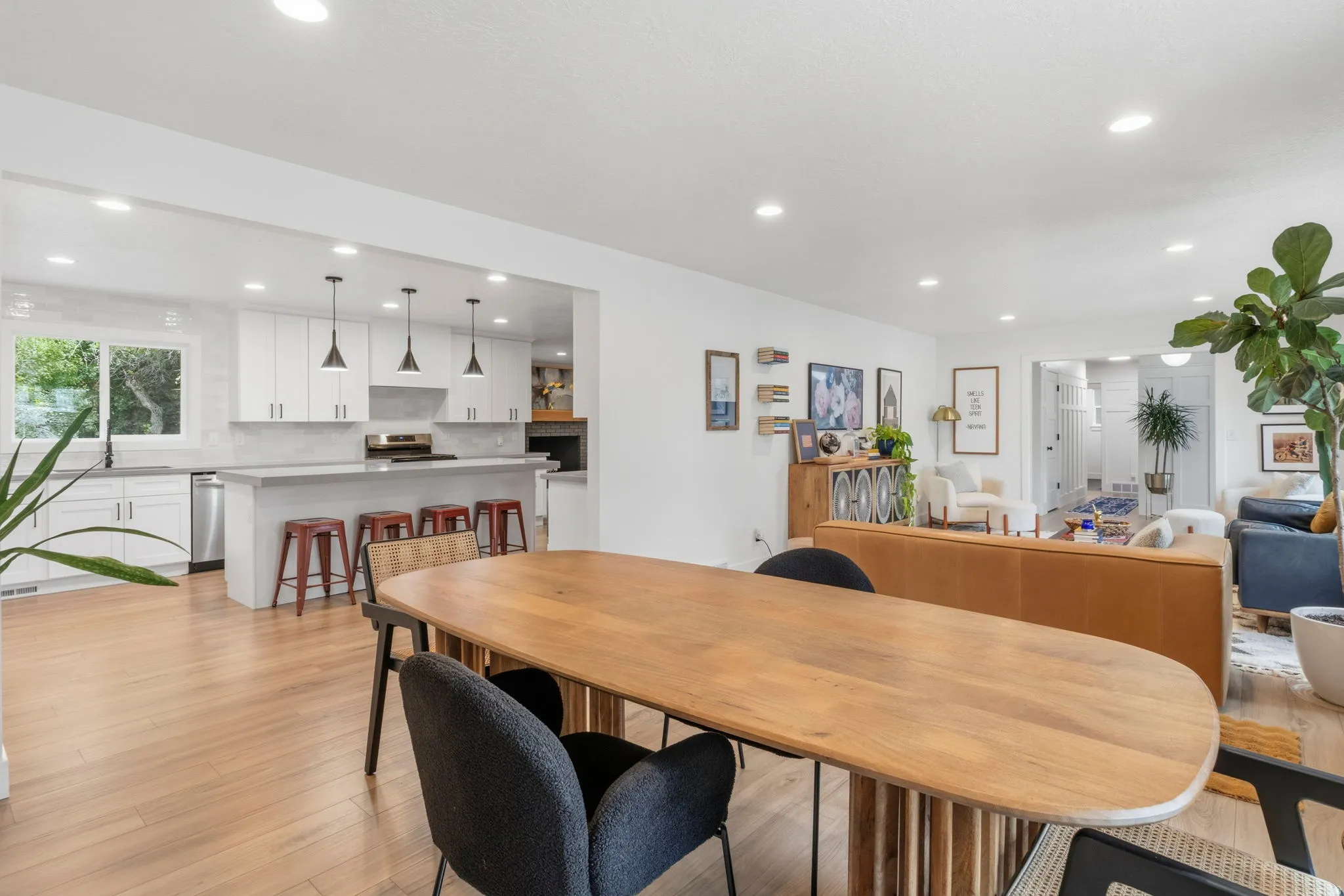 Open-concept living space featuring wood-finish flooring, recessed lighting, and a kitchen with white cabinetry