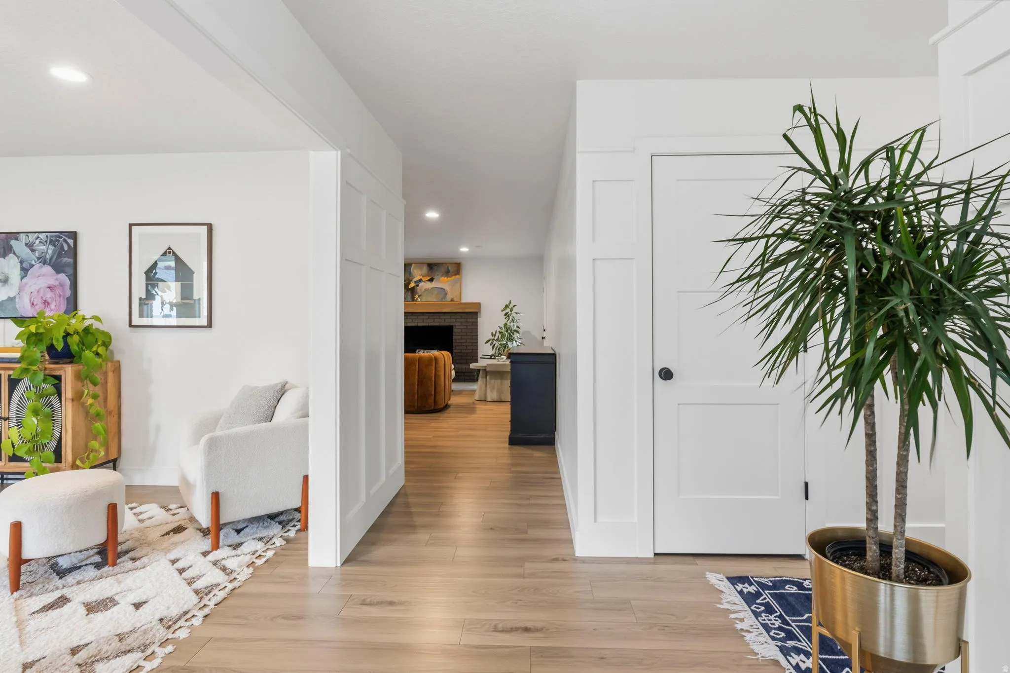 Light wood-finish flooring throughout, featuring crisp white walls and recessed lighting