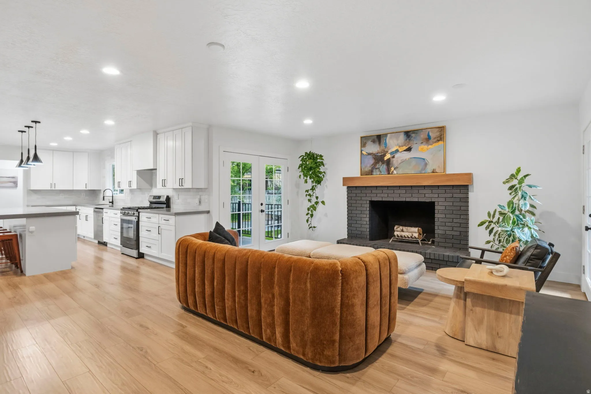 Spacious open-concept interior featuring light wood-finish flooring throughout