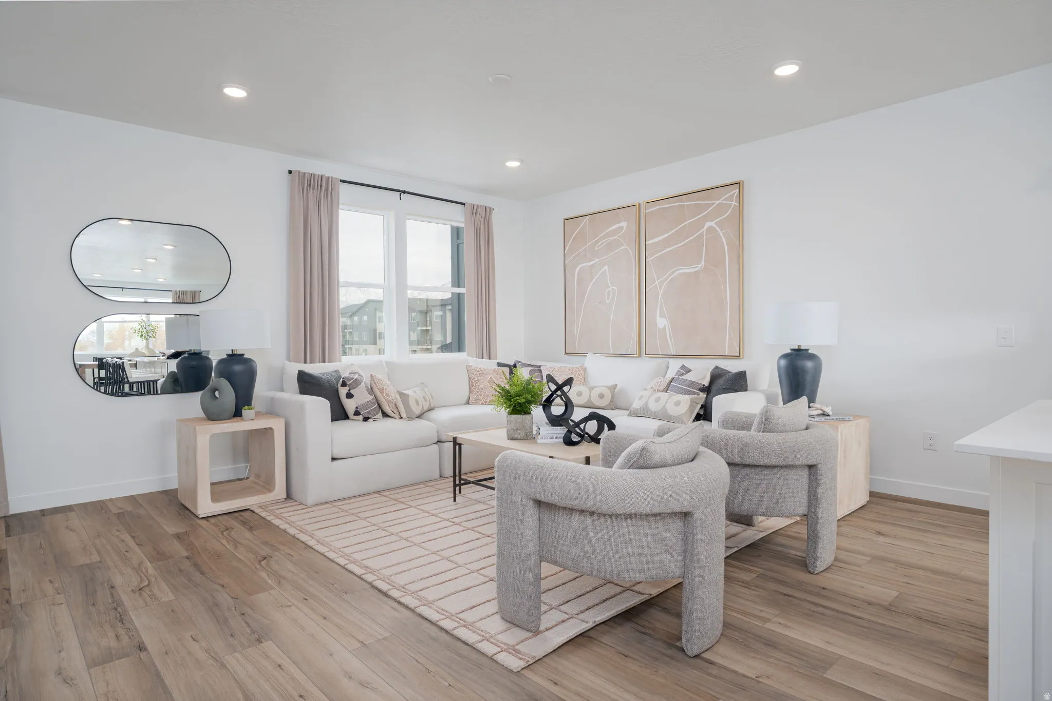 Spacious living area featuring expansive windows, recessed lighting, wood-finish flooring, and crisp white walls