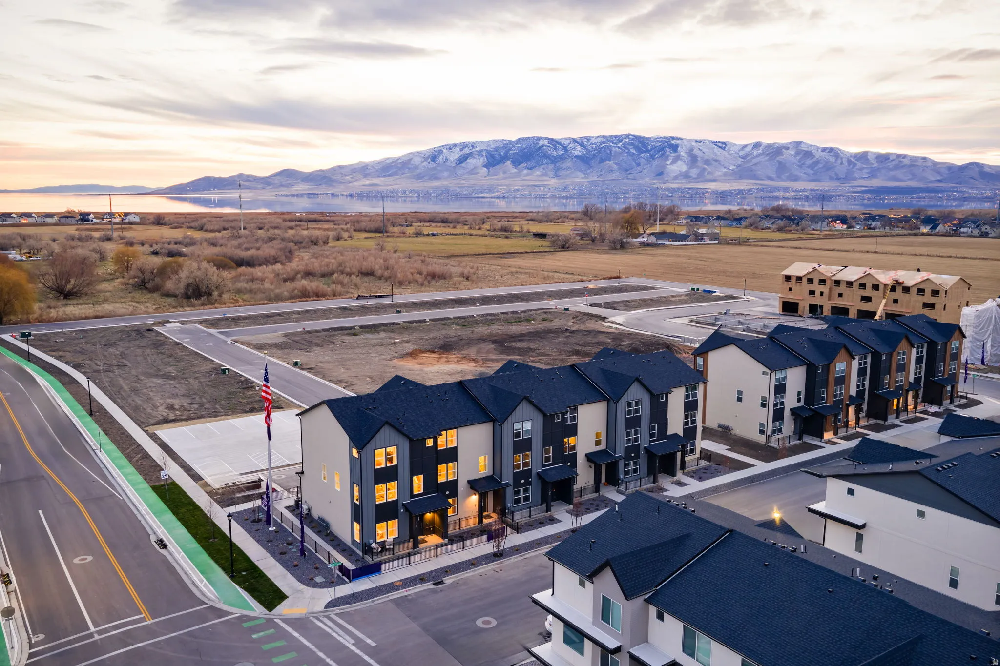 Newly constructed townhomes featuring contemporary facades with dark roofing, light siding, and dark trim accents