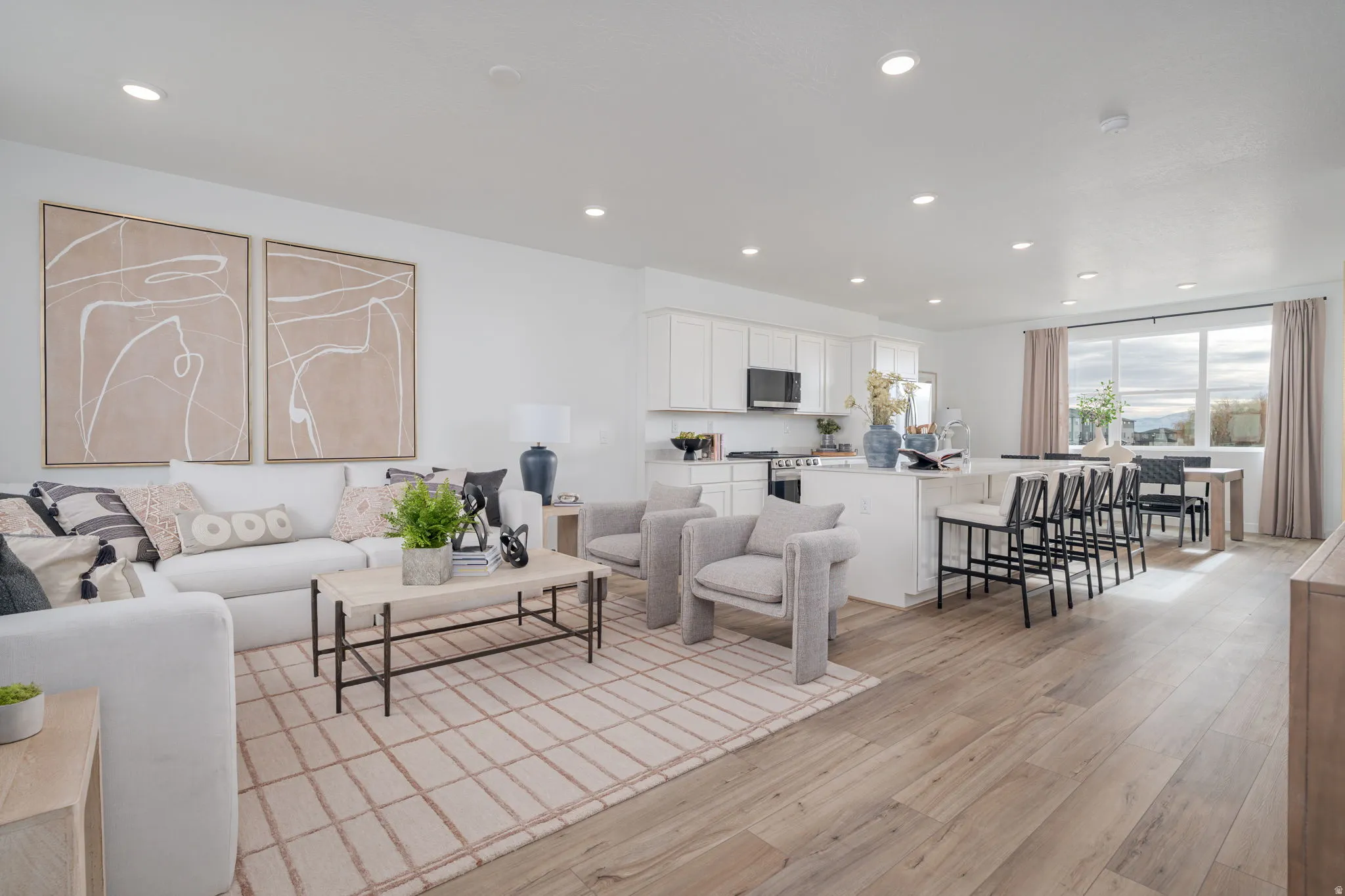 Open-concept living space featuring wood-finish flooring, recessed lighting, and a neutral color palette