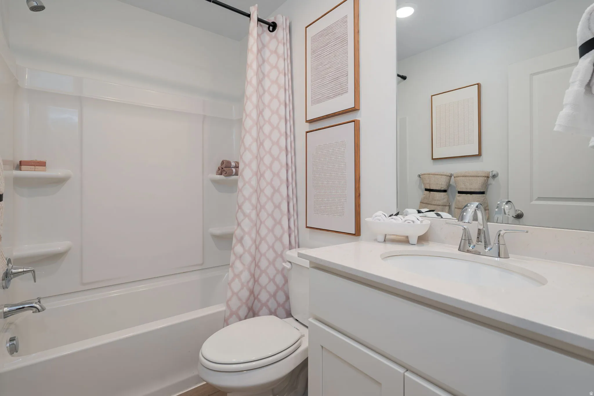 Bright bathroom with a white vanity featuring a polished chrome faucet and an integrated sink, set against a large mirror