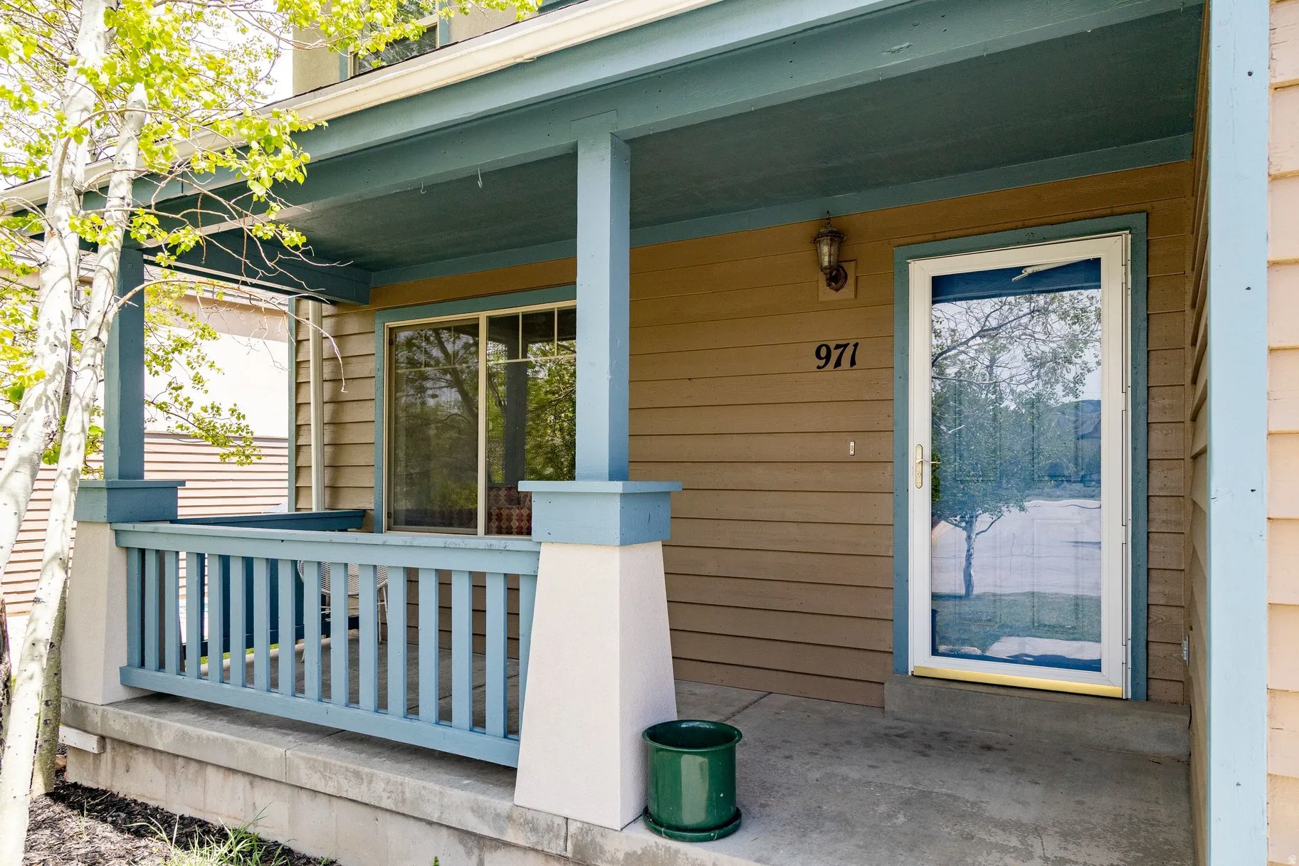 Inviting front porch featuring a screen door entrance, sliding glass door, and protective railing