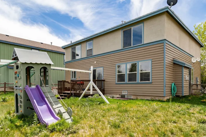 Rear exterior featuring a multi-level deck, horizontal siding, stucco elements, and visible window placements