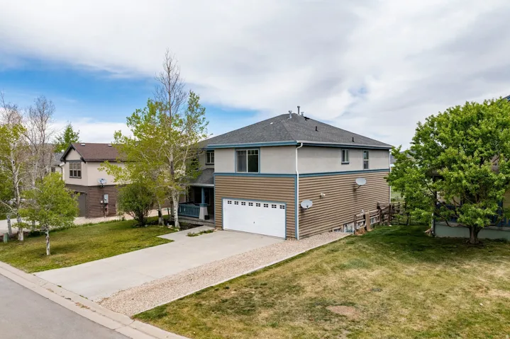 Two-story residence featuring a combination of siding and stucco, an attached two-car garage, and a covered front porch