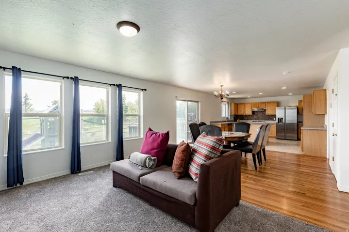 Open-concept interior featuring wood-finish flooring, recessed lighting, and a kitchen with wood cabinetry