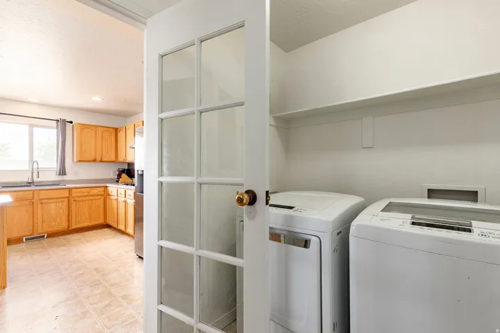 Dedicated laundry area featuring a built-in shelf and ample space for appliances