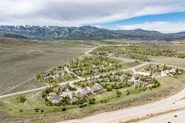 Mountain community featuring a residential area with varied home styles, winding roads, and mature trees