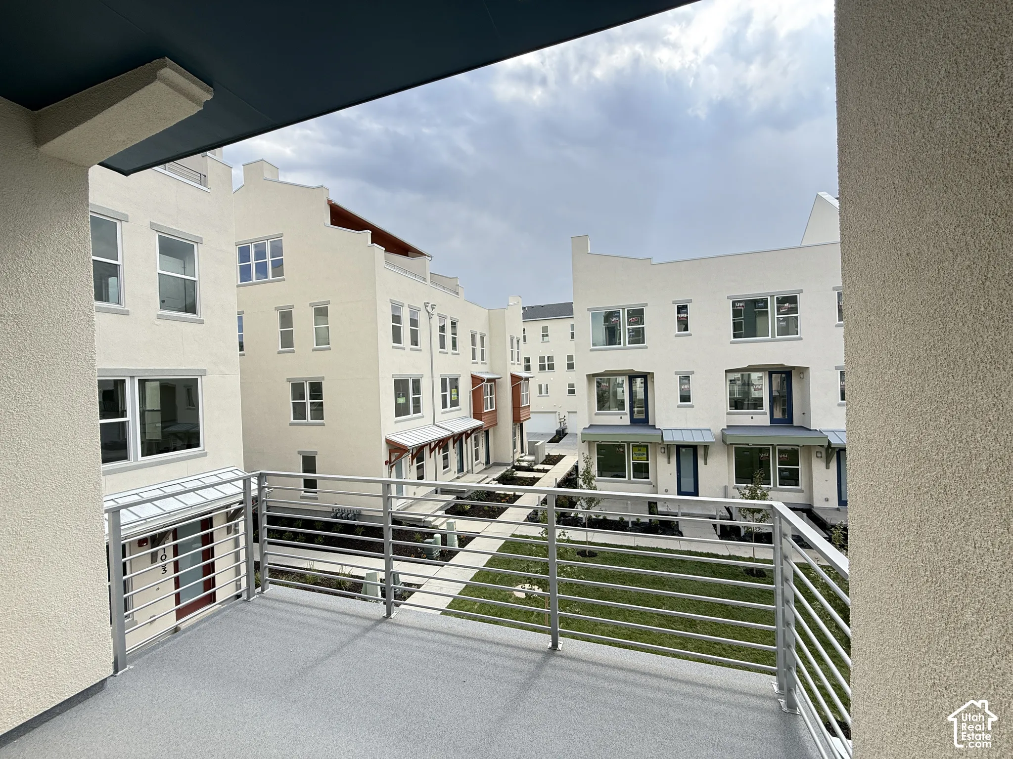 Private balcony with a gray textured surface and horizontal bar railing
