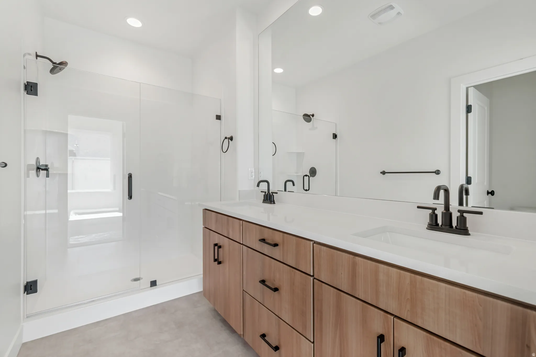 Contemporary bathroom featuring a double vanity with wood-finish cabinetry and white countertops