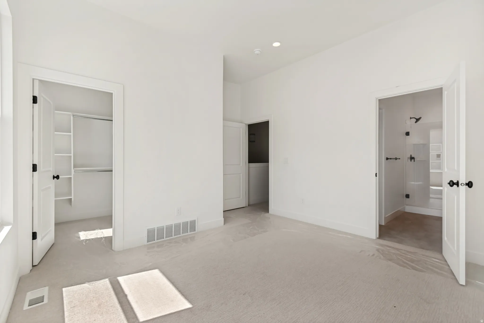 Carpeted interior space featuring white walls and trim, recessed lighting, and a window