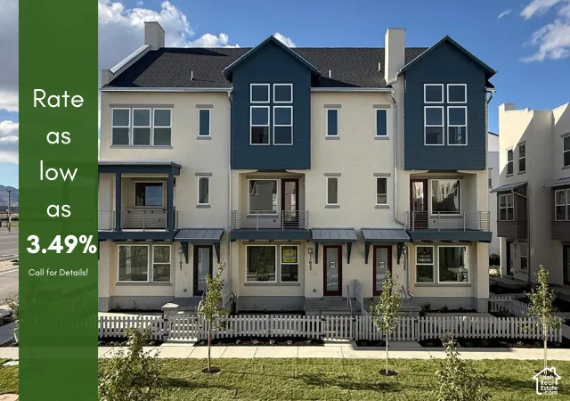 Modern townhome architecture featuring a light-colored stucco exterior and contrasting dark blue siding