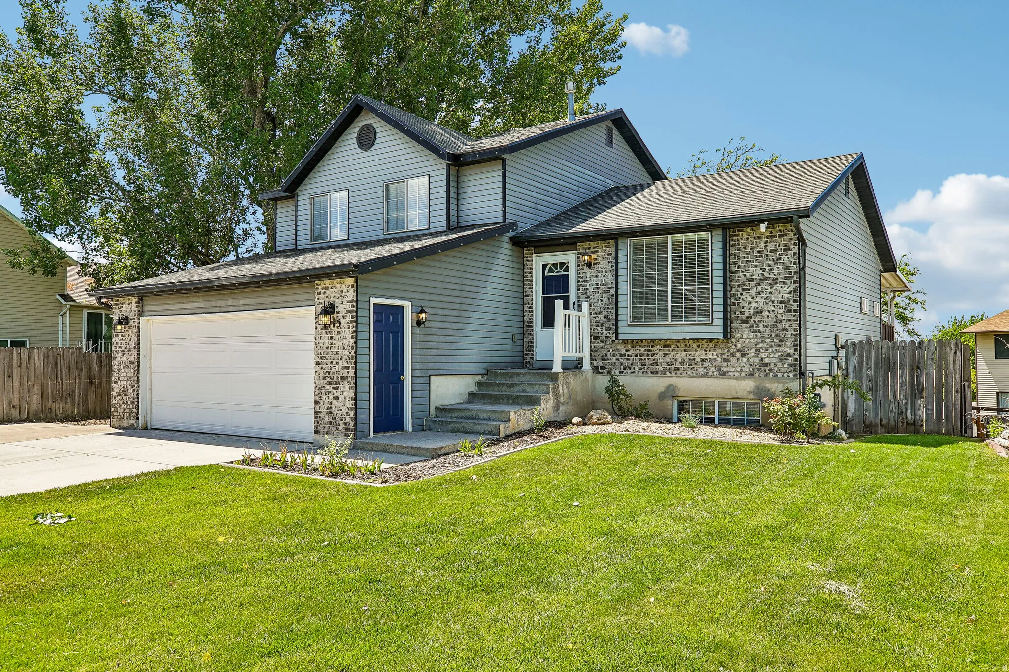 Two-story residence featuring light blue siding and stone accents