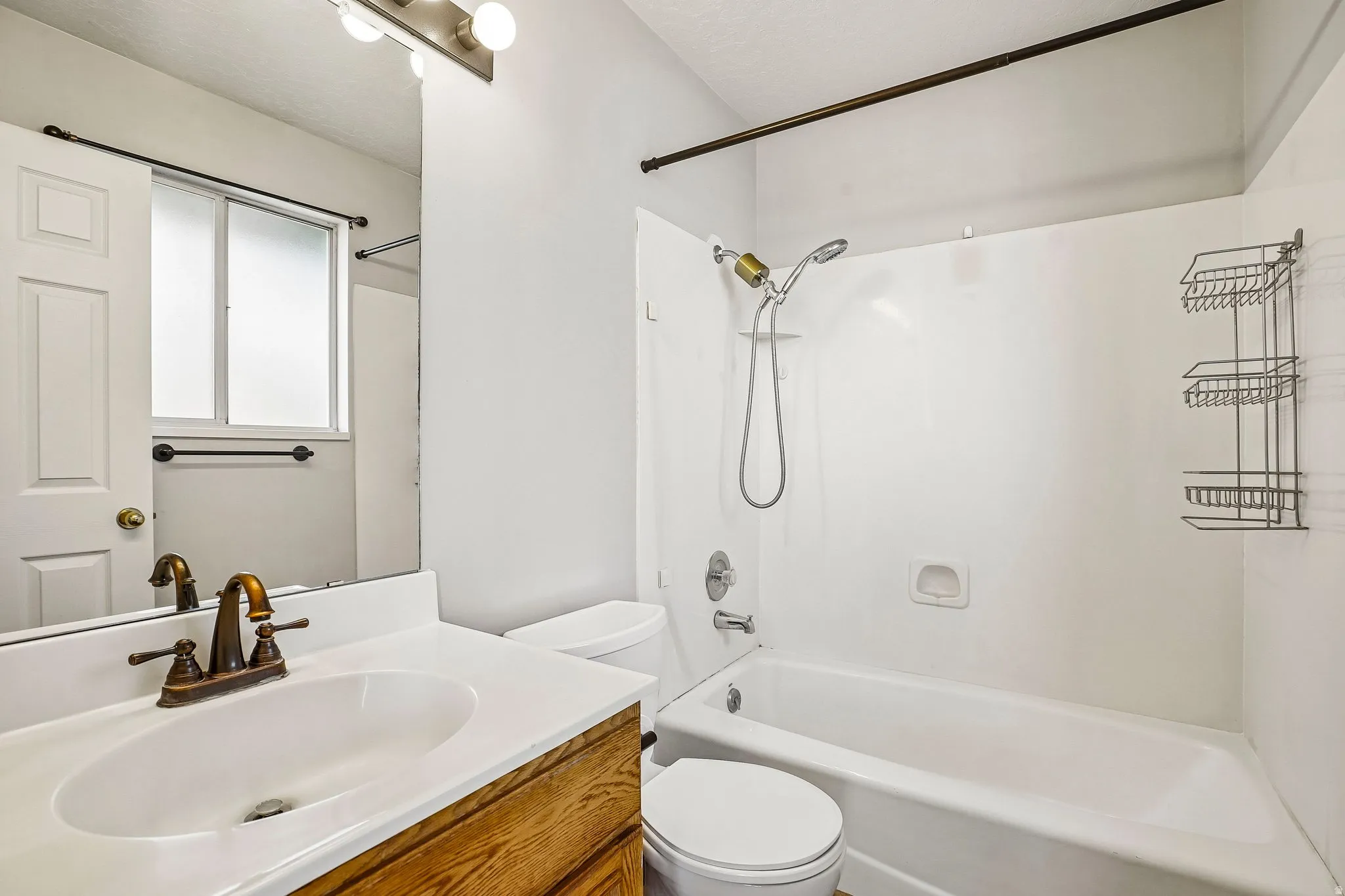 Bathroom featuring a white vanity with an integrated sink, bronze-finish faucet, and coordinating bronze-finish light fixture