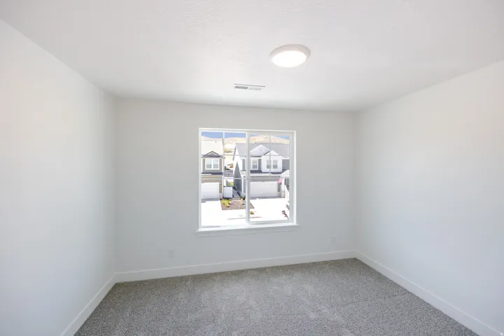 Recessed lighting, white walls, carpet flooring, and a large window
