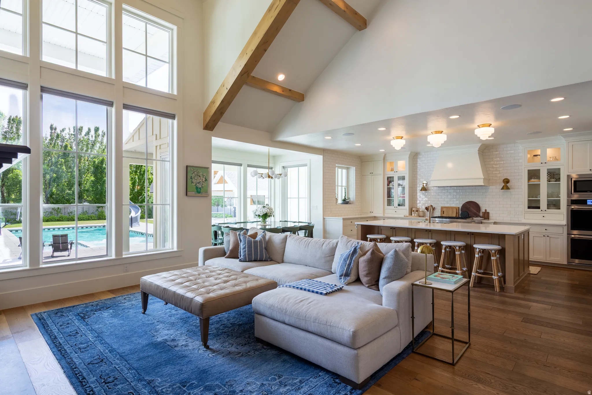 Open-concept living space featuring vaulted ceilings with exposed wood beams