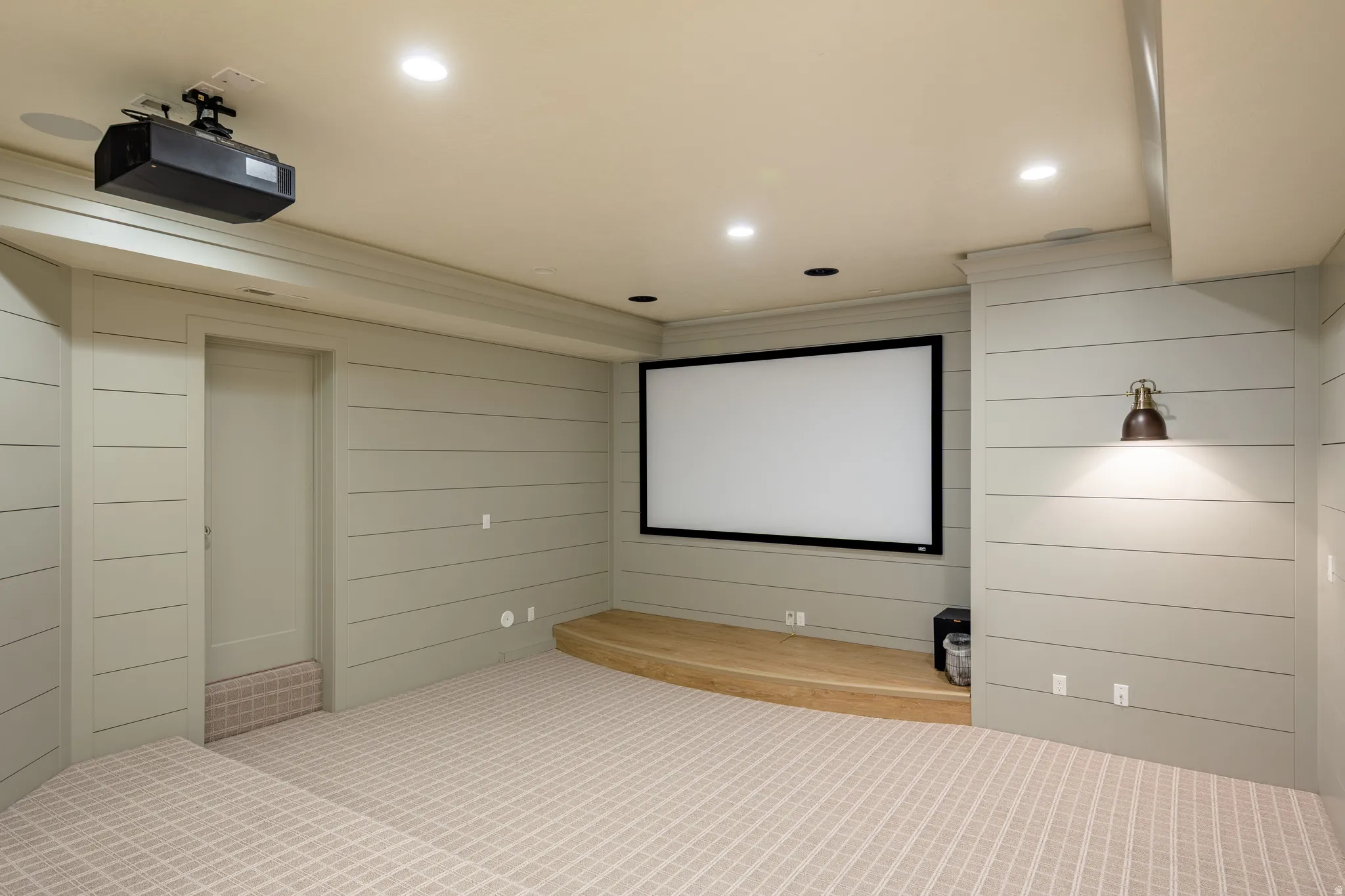 Dedicated media room featuring a mounted projector and large projection screen