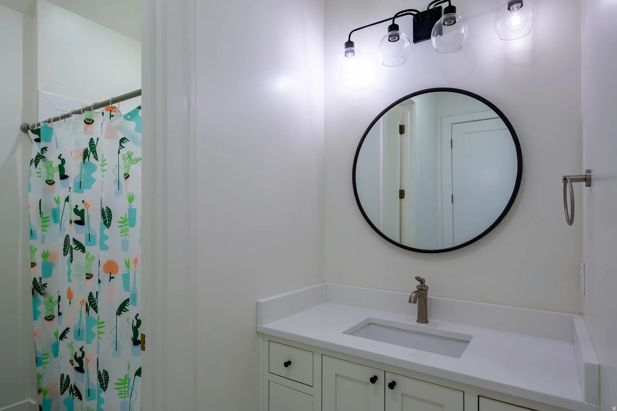 Bathroom vanity featuring a rectangular undermount sink, a countertop, and cabinet storage