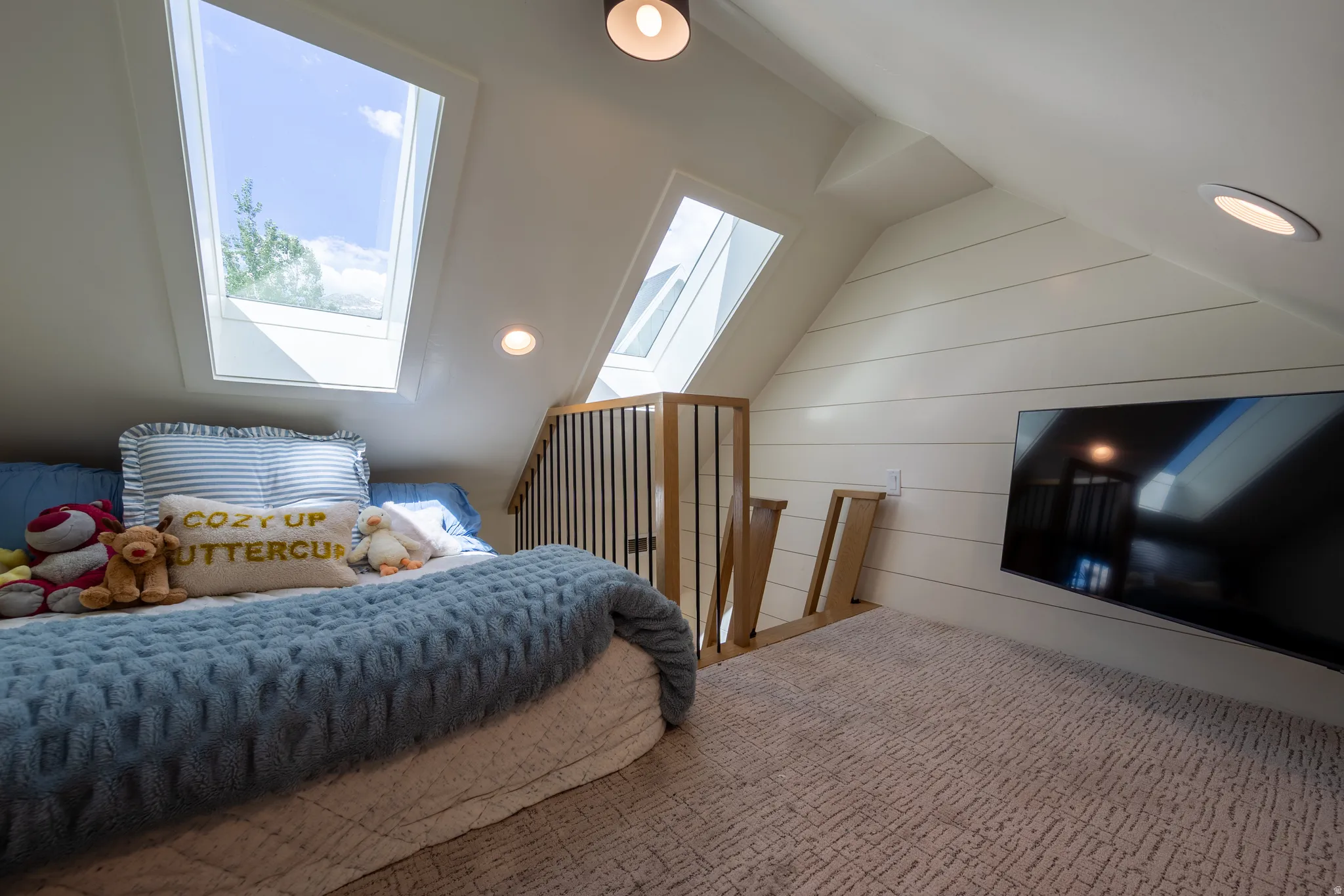 Loft space with angled ceilings and dual skylights