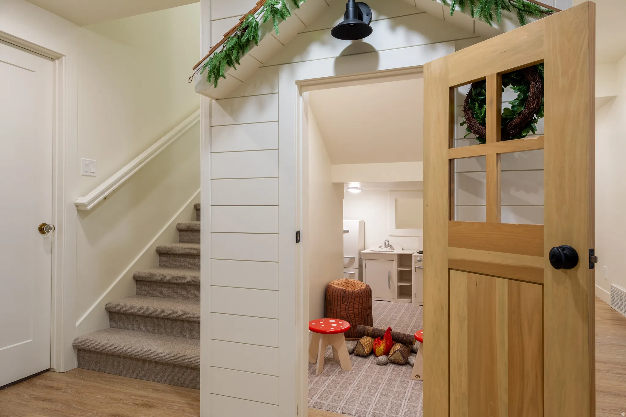 Finished lower level with wood-finish flooring and carpeted staircase