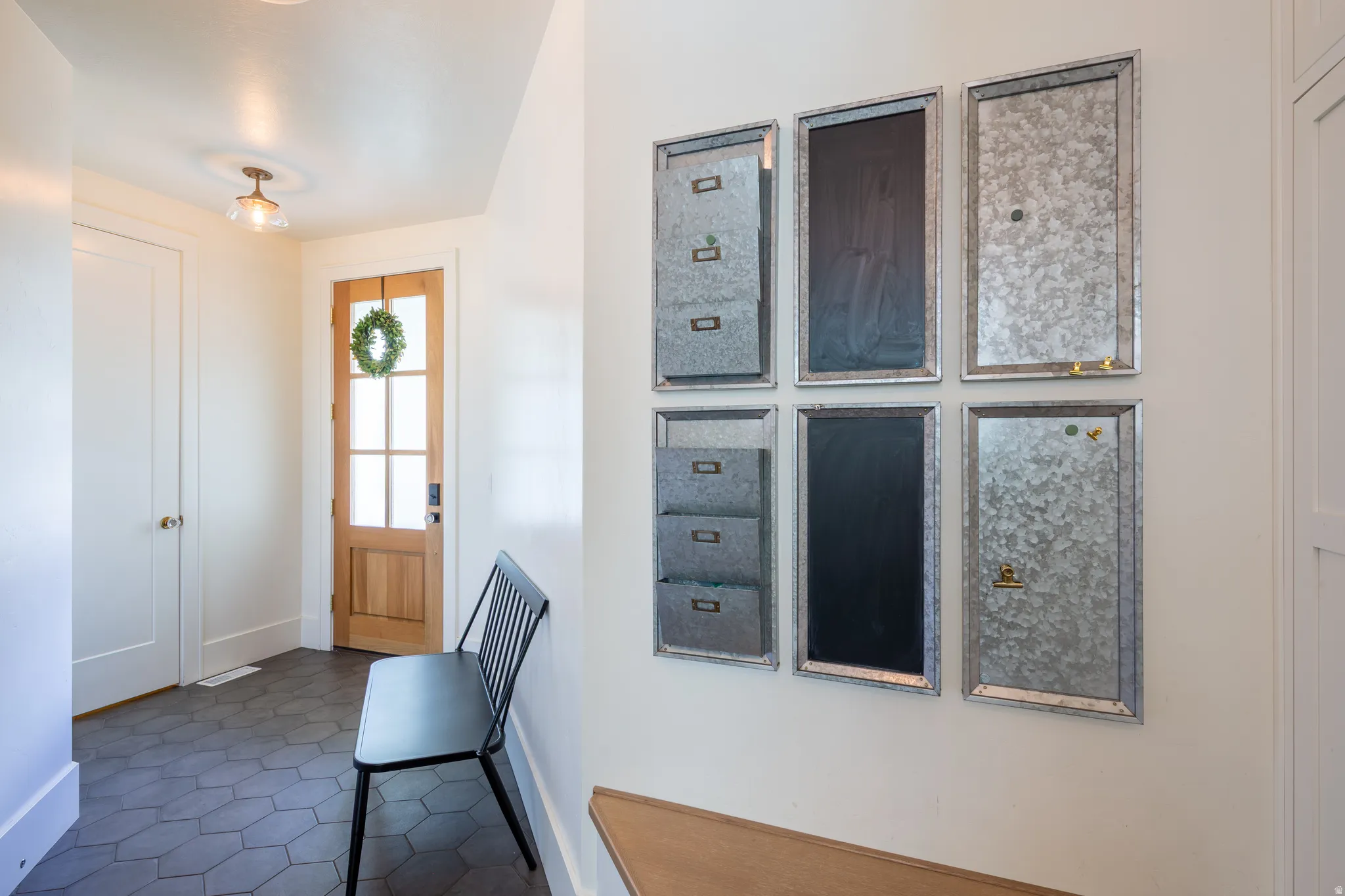 Entryway featuring hexagon tile flooring, a natural wood door with glass panes, and a contemporary ceiling light fixture