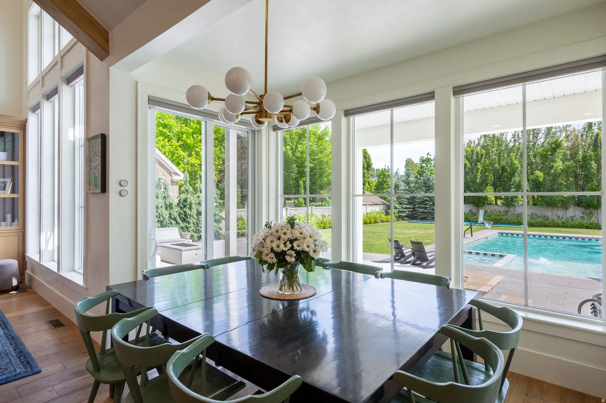 Dining area with hardwood-finish flooring, a contemporary chandelier, and a built-in shelving unit