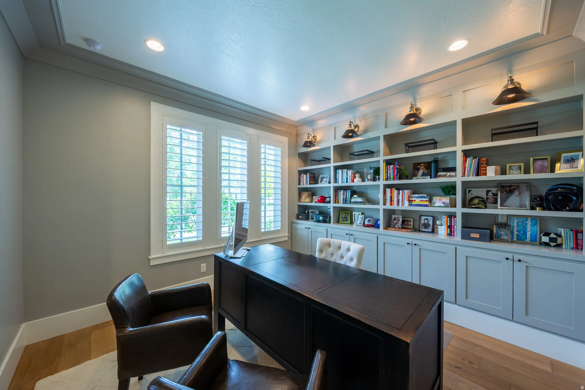 Dedicated workspace featuring extensive custom built-in cabinetry and shelving with integrated lighting