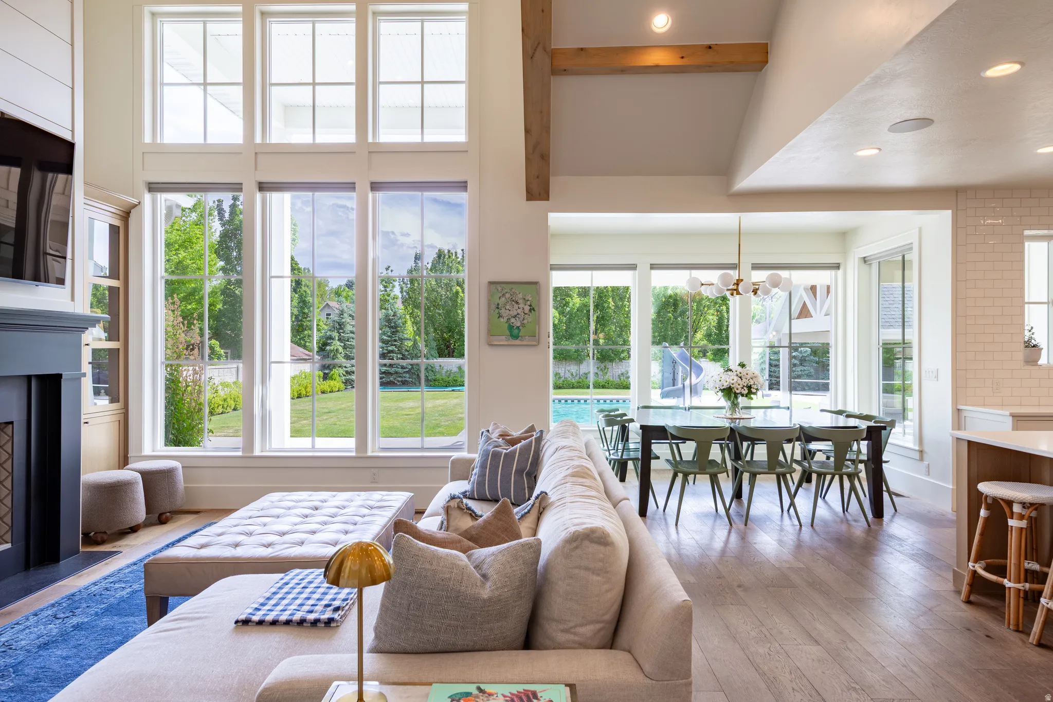 Spacious living area featuring floor-to-ceiling windows, a dark-toned fireplace with mantel, and built-in cabinetry