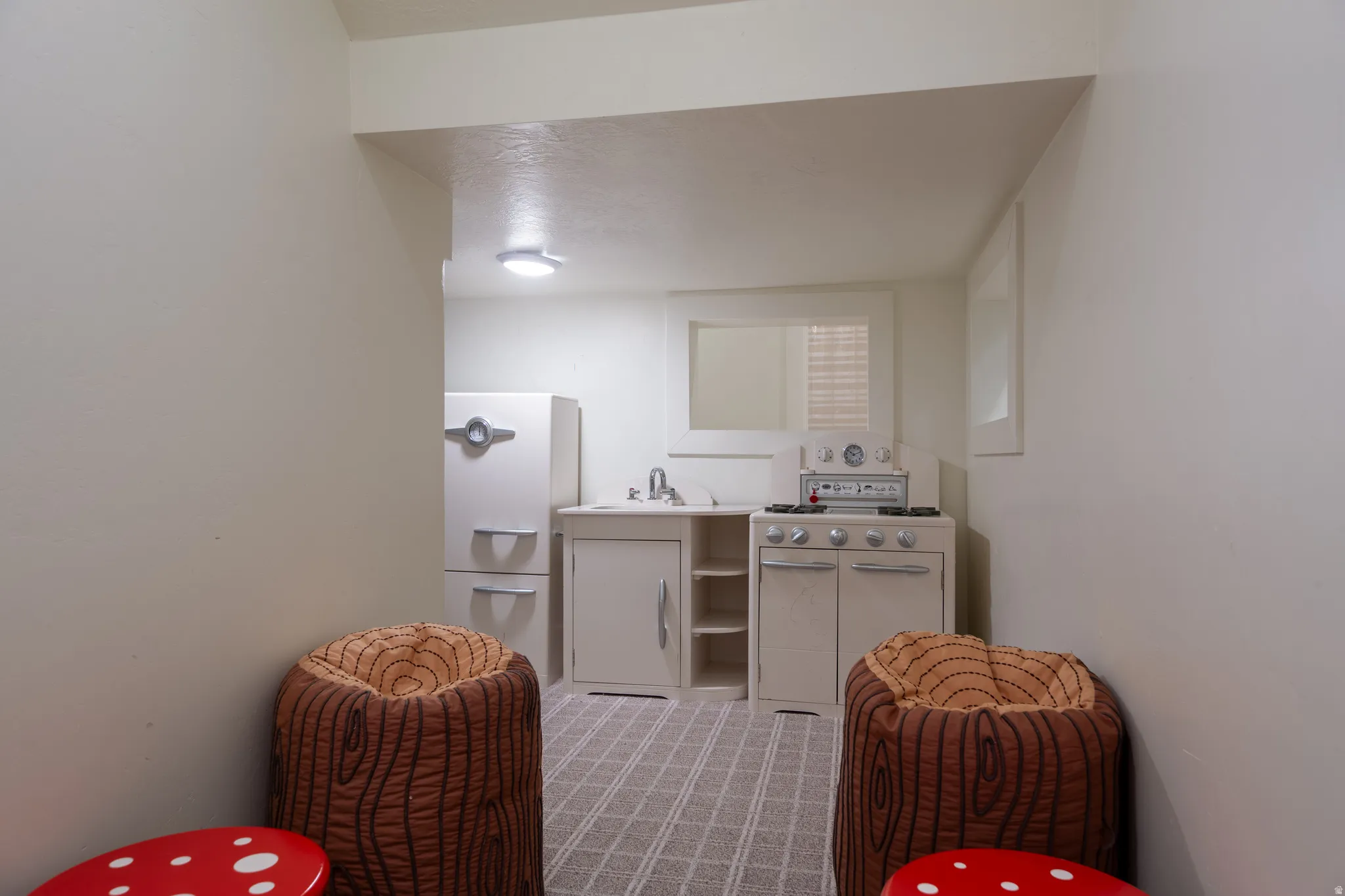Built-in white cabinetry featuring a sink, range, and refrigerator