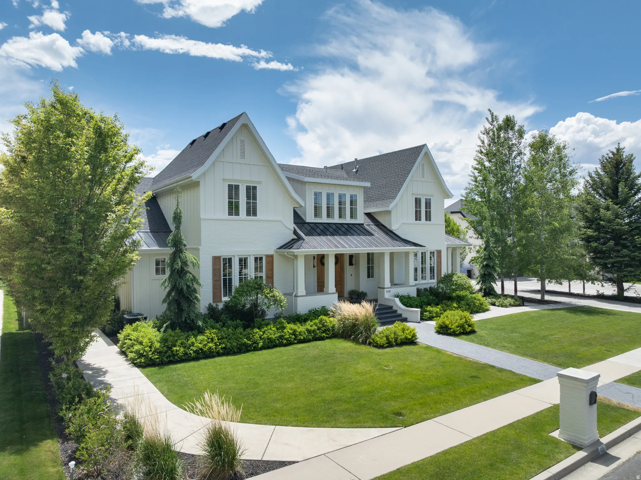 Modern farmhouse-style residence with white siding and a dark shingled roof