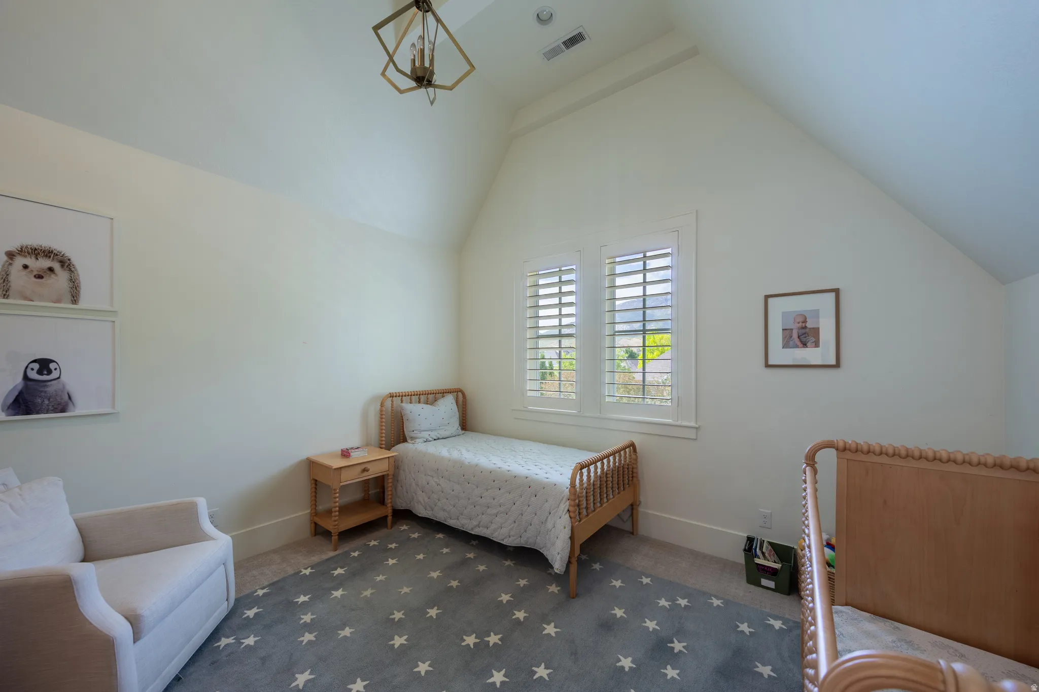 Vaulted ceiling room featuring plantation shutters, neutral wall tones, and light wood-finish flooring