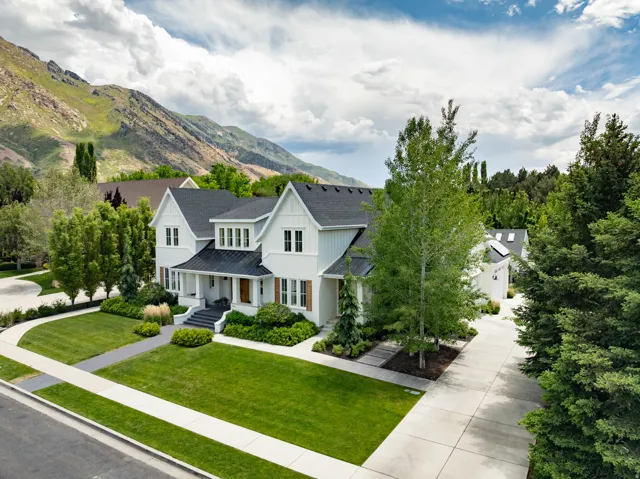 Striking two-story residence featuring light-colored siding, multiple gables, and dark roofing