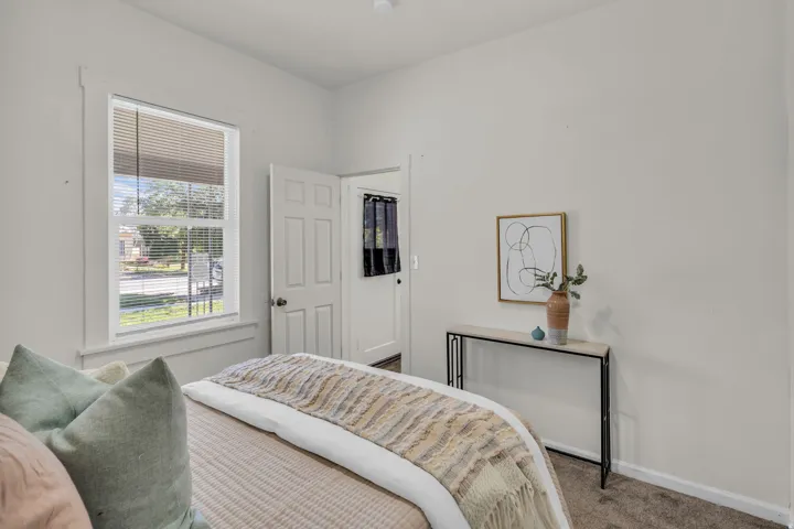 Carpeted room featuring a single window with blinds and white trim