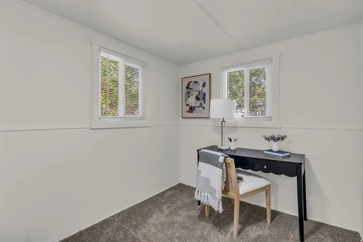 Light gray carpeting paired with white walls, baseboards, and window trim