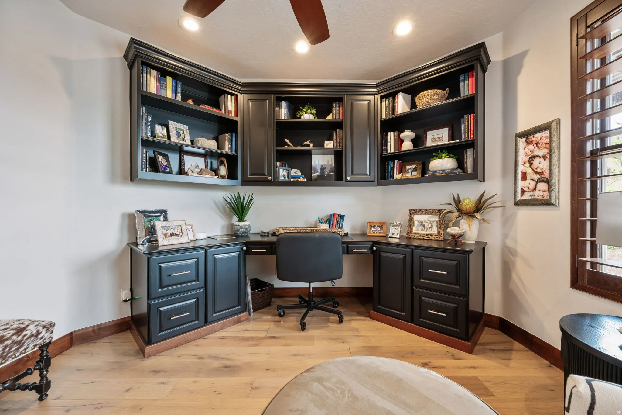 Custom built-in desk with dark cabinetry and integrated shelving