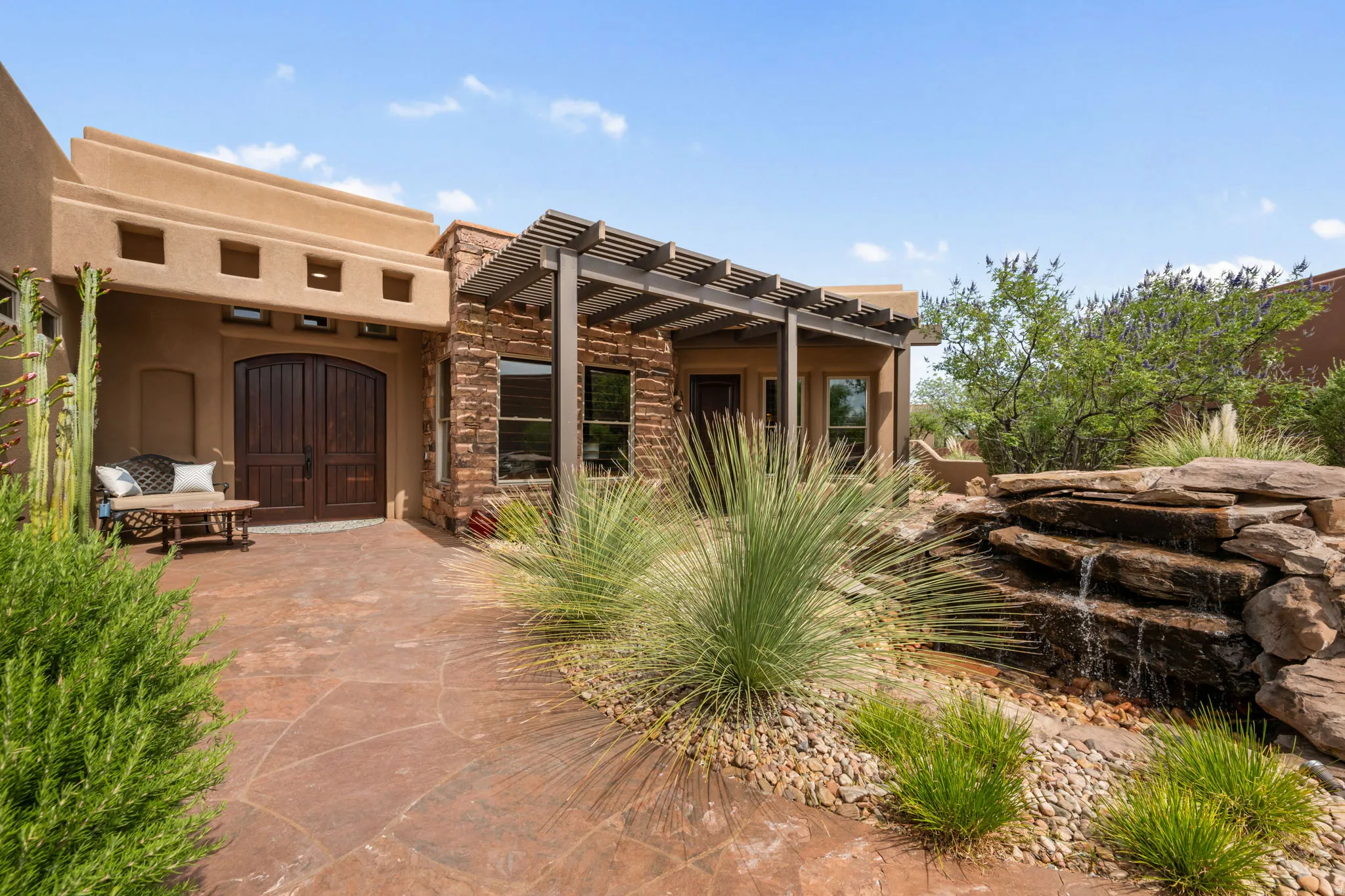 Southwestern architectural style featuring a textured stucco exterior and a stone-clad facade