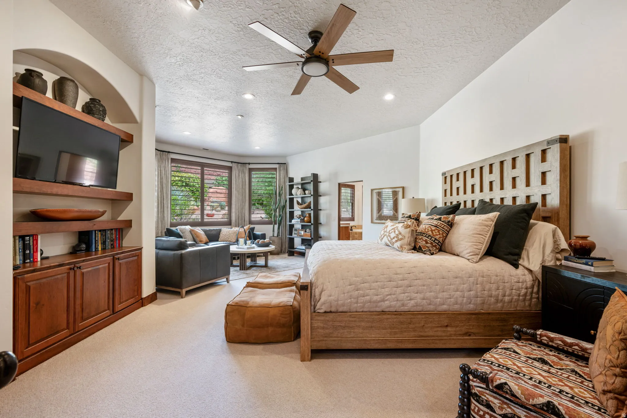 Spacious room featuring a light-toned carpet, a vaulted ceiling, and a ceiling fan with integrated lighting