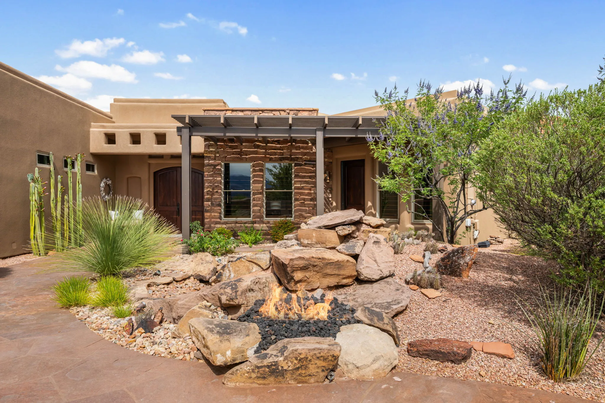 Front exterior featuring a stucco facade and a prominent stone accent wall