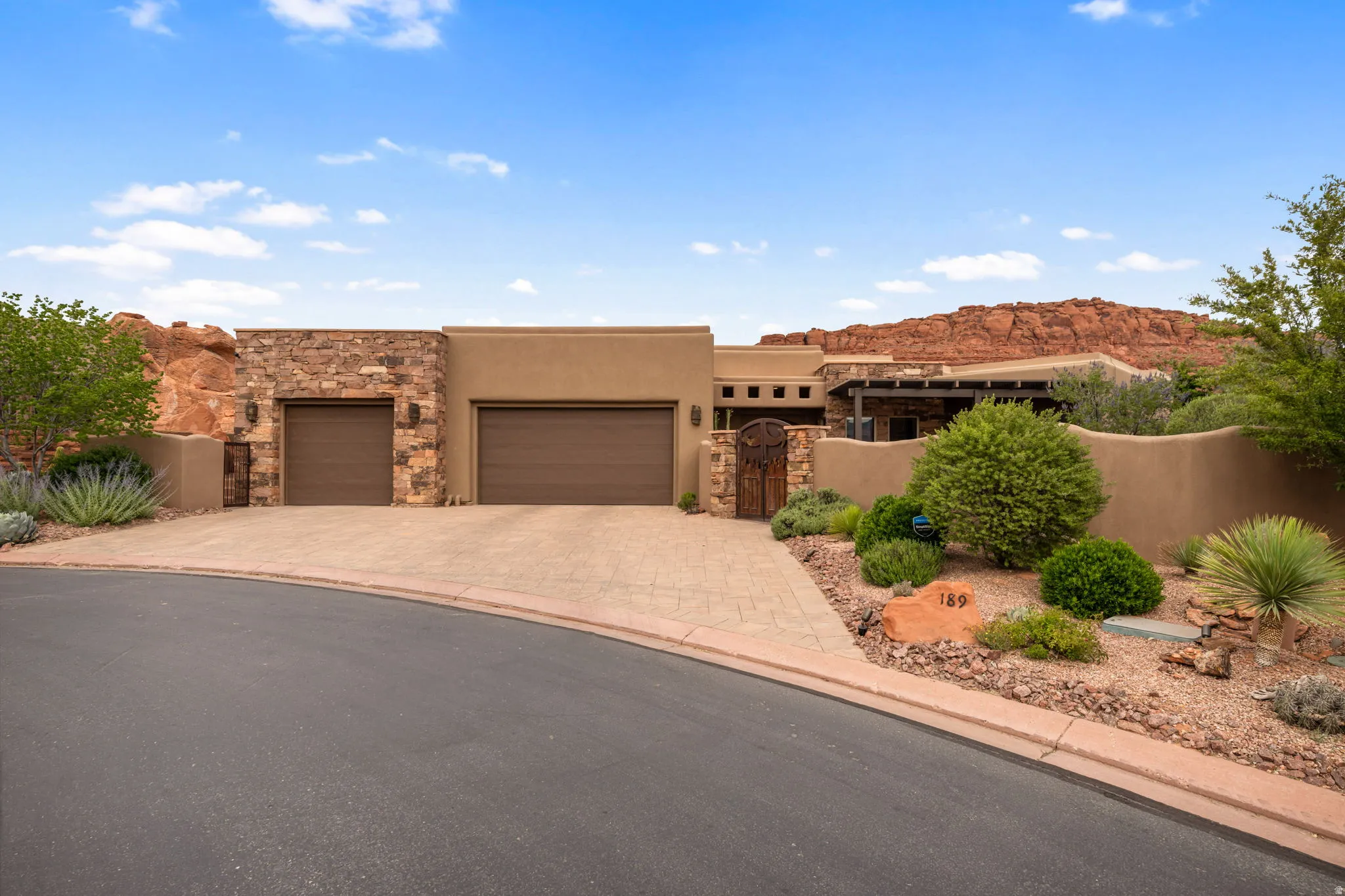 Stucco exterior with stone accents, a two-car garage, and an additional single-car garage