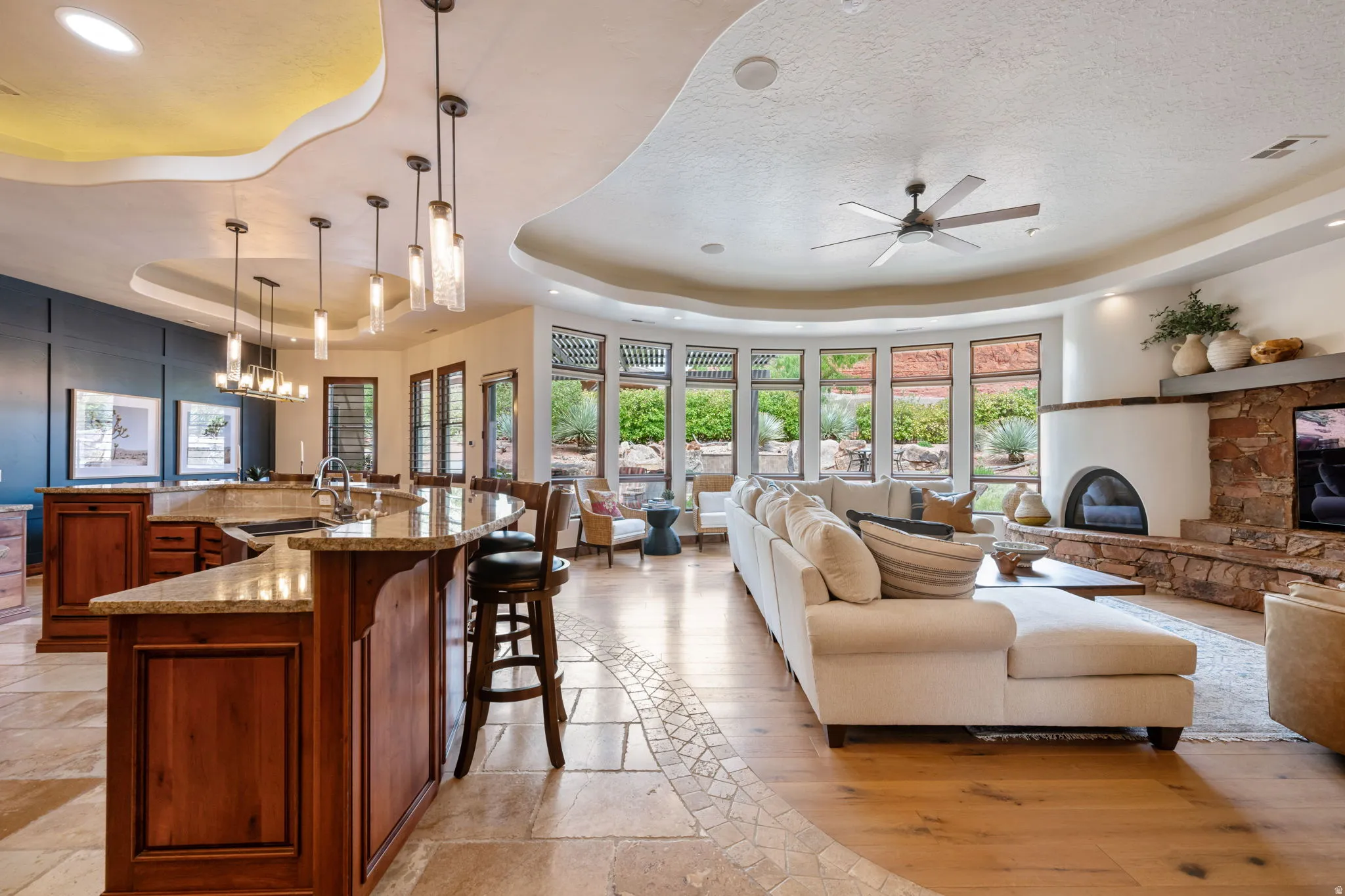 Open-concept living space featuring a custom kitchen island with granite countertops, wood-finish cabinetry, and pendant lighting