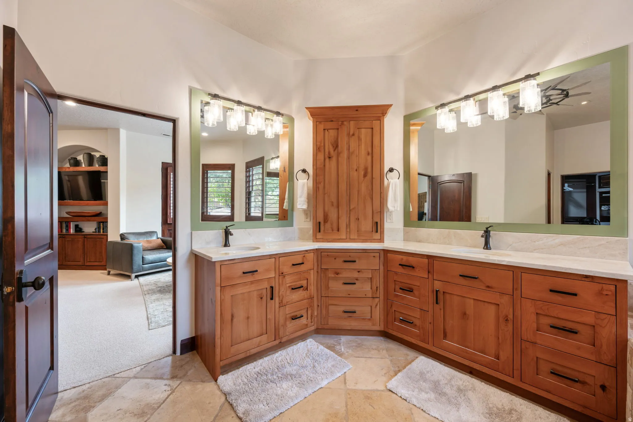 Corner vanity featuring natural wood cabinetry, light-toned countertop, and two integrated sinks