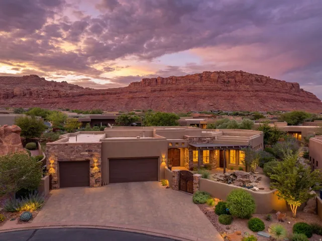 Adobe-style residence with a desert landscape featuring a prominent red rock mountain backdrop