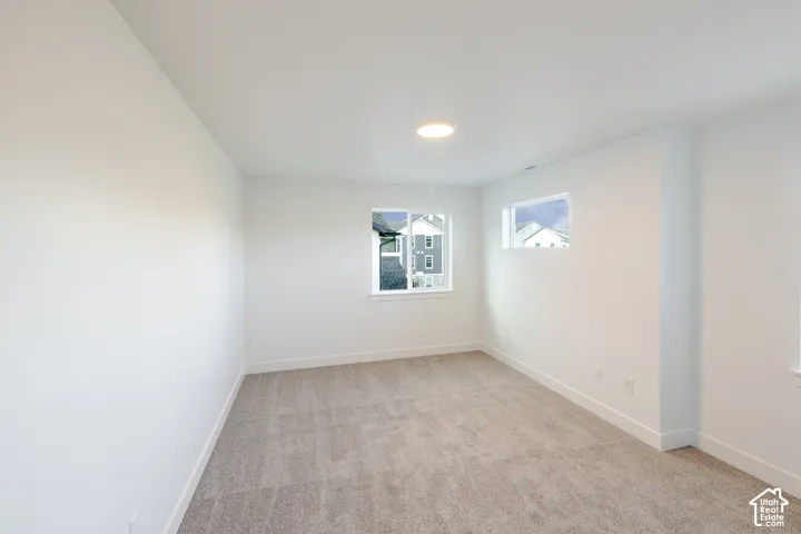 Recessed ceiling lighting, two windows, and light gray carpeting