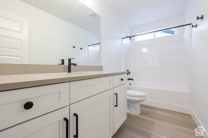 White shaker-style vanity with matte black hardware, light-toned countertop, and undermount sink